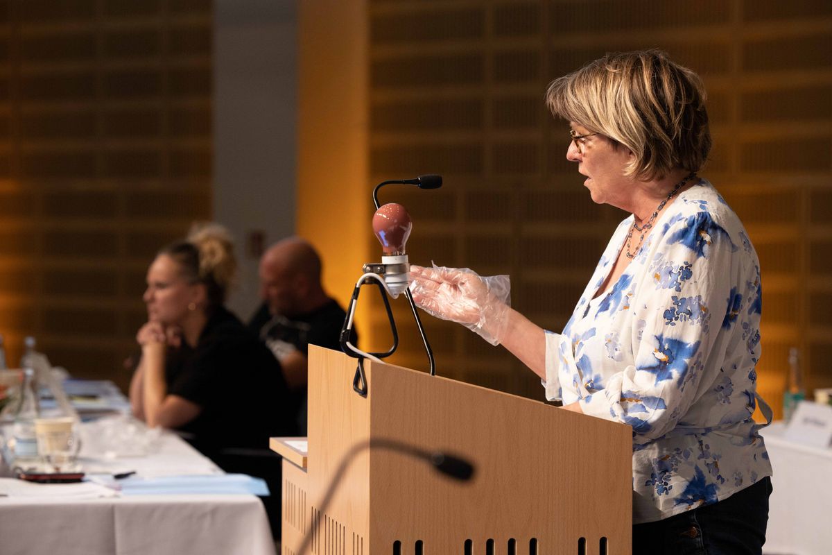 Næstformand, Inge Thomsen, på talerstolen med plastikhandsker som et af  sikkerhedstiltagene på generalforsamlingen. Foto: Berit Jørgensen